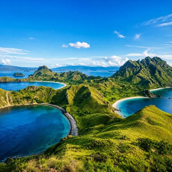 Padar Island viewpoint overlooking three turquoise bays and dramatic green hills in Komodo National Park, Indonesia
